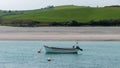 A small motor boat moored in shallow water. Sandy beach. Seascape. White boat on body of water