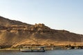 Small motor boat for the tourist ride on the Nile River in Cairo Egypt, in the background ruins of an ancient Arab town in the d Royalty Free Stock Photo