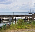 Small motor boats moored on wooden poles of the pier of a small port in Lake Trasimeno Umbria, Italy Royalty Free Stock Photo