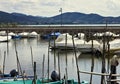 Small motor boats moored on wooden poles of the pier of a small port in Lake Trasimeno Umbria, Italy Royalty Free Stock Photo