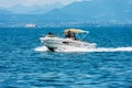 Small Motorboat with a Family on Board in motion on Lake Garda - Italy Royalty Free Stock Photo