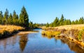 Small mountain creek meandering in the middle of meadows and forest. Sunny day with blue sky and white clouds in Jizera Royalty Free Stock Photo