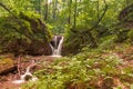 A small mountain river at the bottom of a deep gorge, a small waterfall Royalty Free Stock Photo