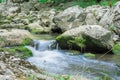 Small mountain waterfall on the rocks covered with moss deep in the forest Royalty Free Stock Photo