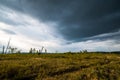 Small mountains, illuminated by the setting sun, and storm clouds in the sky Royalty Free Stock Photo