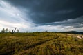 Small mountains, illuminated by the setting sun, and storm clouds in the sky Royalty Free Stock Photo