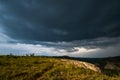 Small mountains, illuminated by the setting sun, and storm clouds in the sky Royalty Free Stock Photo