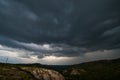 Small mountains, illuminated by the setting sun, and storm clouds in the sky Royalty Free Stock Photo