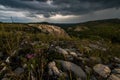 Small mountains, illuminated by the setting sun, and storm clouds in the sky Royalty Free Stock Photo