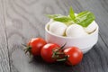 Small mozzarella balls in white bowl with plum