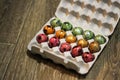 Small multi-colored testicles in a box. three colors - green, red and orange. a box on a floor