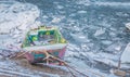 Small multicolor fishing boats trapped on frozen river Danube