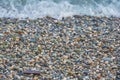 Small multicolored sea pebbles washed by a wave.