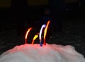 Small multicolored torches standing in snow Royalty Free Stock Photo