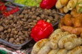 Small mushrooms lie on a large tray next to red bell peppers, various meat sausages and other foods. Royalty Free Stock Photo