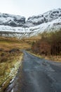 Small narrow country road into mountains covered with snow, Winter season. Gleniff Horseshoe Drive, county Sligo, Ireland Royalty Free Stock Photo