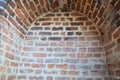 A small narrow recess, a niche with an arch on an old ancient stone red thick brick wall in an old castle. The background Royalty Free Stock Photo