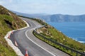 Small narrow road by the ocean, Achill Island, county Mayo, Ireland. Warm sunny day. Irish landscape. Blue clear cloudy sky. Royalty Free Stock Photo