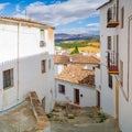 A small narrow street with white houses and abundant greenery in the old European city. Ronda, Andalusia, Spain. Panorama Royalty Free Stock Photo