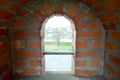 A small narrow window on an old ancient stone thick brick wall in an old castle. The background Royalty Free Stock Photo