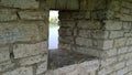 Small narrow window in the old ancient stone wall of Kremlin Pskov, Russia. View of the river through the gap. Concept of chance o Royalty Free Stock Photo