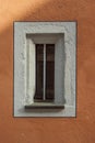 Small narrow window in an old restored building with new painted facade Royalty Free Stock Photo