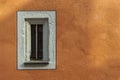 Small narrow window in an old restored building with new painted facade Royalty Free Stock Photo