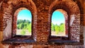 Small narrow windows on an old, ancient, cracked stone shabby brick wall of red brick in church. Architecture background Royalty Free Stock Photo