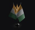 Small national flags of the Cote dIvoire on a black background