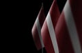 Small national flags of the Latvia on a black background