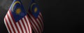 Small national flags of the Malaysia on a dark background