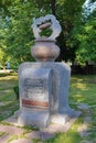 Small neat monument with an inscription and ornament standing on a green meadow