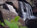 A small New England Waterfall with boulders, rocks and vegetation.