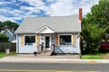 Small nice house with a well-groomed lawn. Blue sky on a sunny day