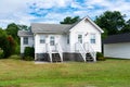 Small nice house with a well-groomed lawn. Blue sky on a sunny day