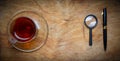 Small notebook with a Cup of tea, stick on a rustic wood background. Royalty Free Stock Photo