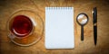 Small notebook with a Cup of tea, stick on a rustic wood background. Royalty Free Stock Photo