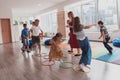 Small nursery school children with female teacher on floor indoors in classroom, doing exercise. Jumping over hula hoop Royalty Free Stock Photo