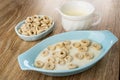 Oat rings in bowl, jug with yogurt, oat rings in blue bowl with yogurt on table