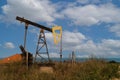 A small oil pump, an energy industrial oil machine, in the agricultural field in Bulgaria. In the background is the Black Sea Royalty Free Stock Photo