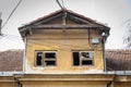 Small old and abandoned damaged house cracked windows with broken glass demolished by the earthquake destruction closeup Royalty Free Stock Photo