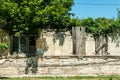 Small old and abandoned house demolished in the earthquake destruction with collapsed roof and broken windows covered with tree br Royalty Free Stock Photo