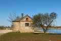 Small and old brick cottage with a chimney close to a canal. Idyllic place for living near to the river Royalty Free Stock Photo