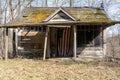 Small old desolated rural wooden house in the wooded area with a flag of USA on the entrance