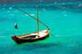 small and old fishing wooden boat with nobody on board sailing in the green Aegean sea. The wooden boa is waiting at harbor Royalty Free Stock Photo