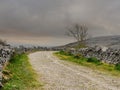 Small old road in the mountains, Storm clouds. Traditional dry stone fence on each side, Burren National Park, Ireland. Rural Royalty Free Stock Photo