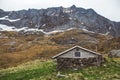 A small old stone and wood house covered with moss on the background of the mountains Royalty Free Stock Photo