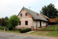 Small old suburban family house with broken facade and dilapidated windows surrounded with freshly cut grass and trees