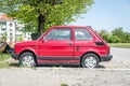 Small old timer Polski Fiat 126 car or Zastava produced from 1972 till 1980 in red color parked on the street. Royalty Free Stock Photo