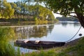 Small old used wooden fishing punt on the bank of a river, bright summer sunny day Royalty Free Stock Photo